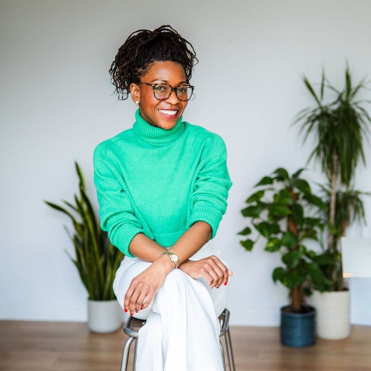 Liana Fricker seated in a green jumper, ready for a Borrow My Brain session