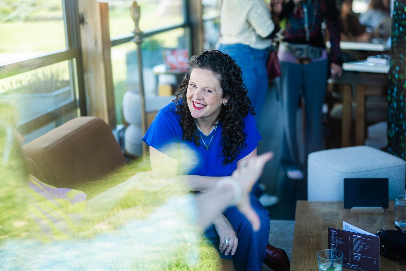A guest laughing during an informal conversation at a house of hopium gathering